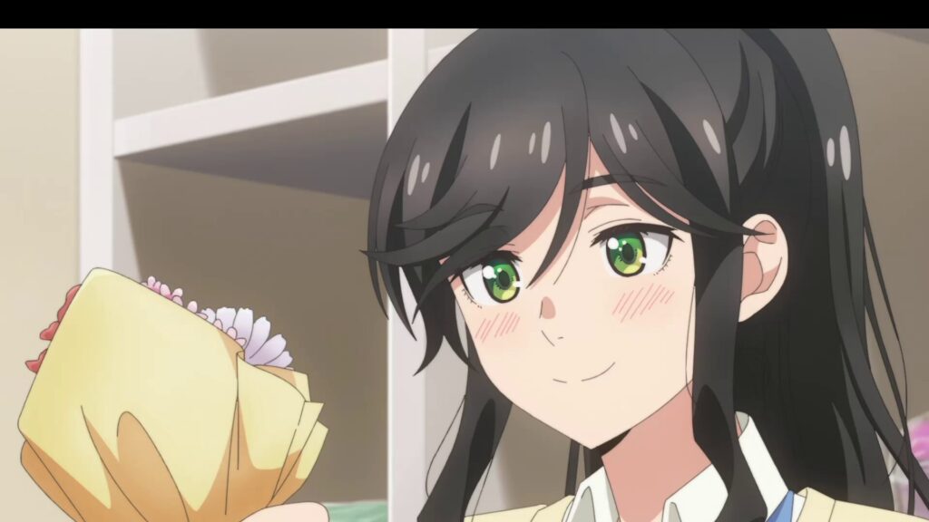 『綺麗にしてもらえますか。』第12話。花束を手に持ち、頬を赤らめながら穏やかに微笑む店主・キンメのバストアップ。室内で窓からの光に包まれている。