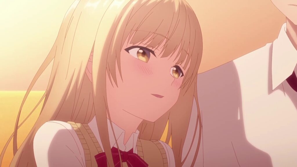 夕焼けに照らされた金髪の少女が、頬を赤らめながら隣の人物へ優しく視線を向けているアニメシーン。